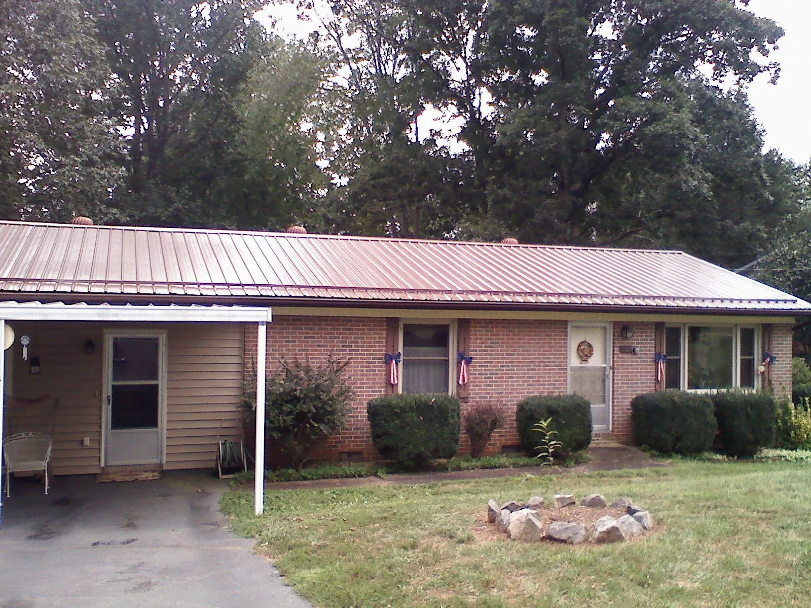 Bronze metal roof and carport on a brick ranch home — Roof Repair work by our crew in Mapleton
